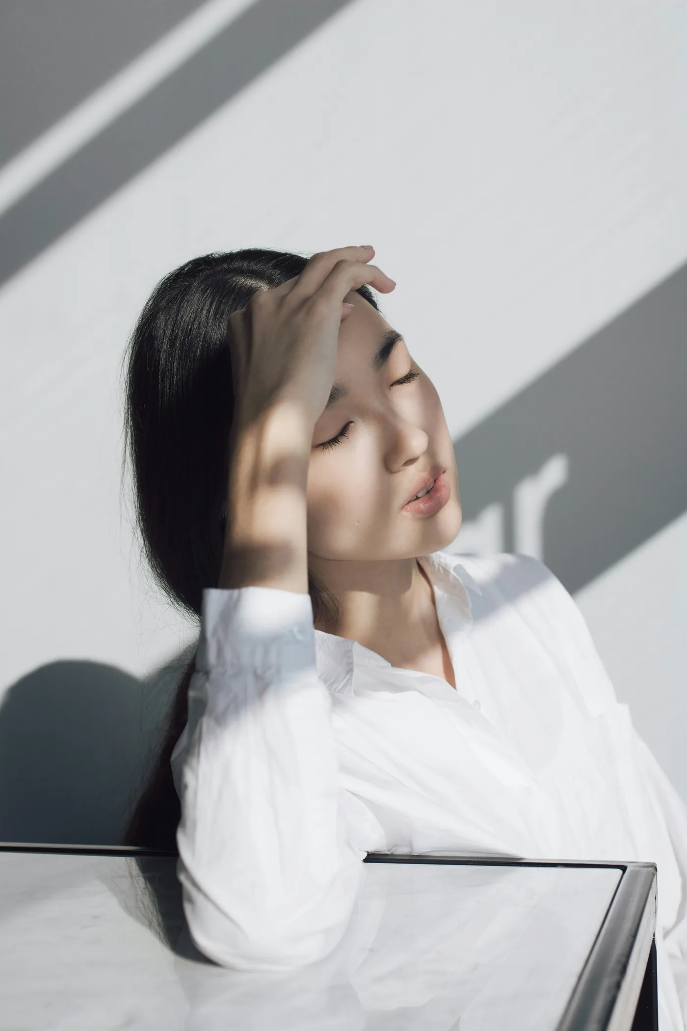 Woman resting in directional window light