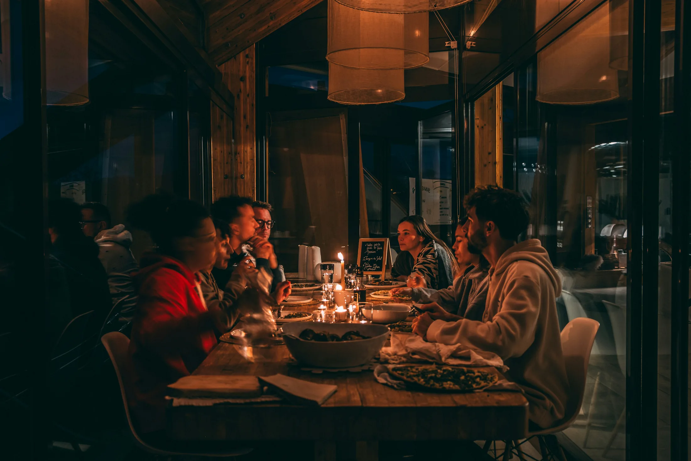 Guests sharing dinner around a warmly lit table