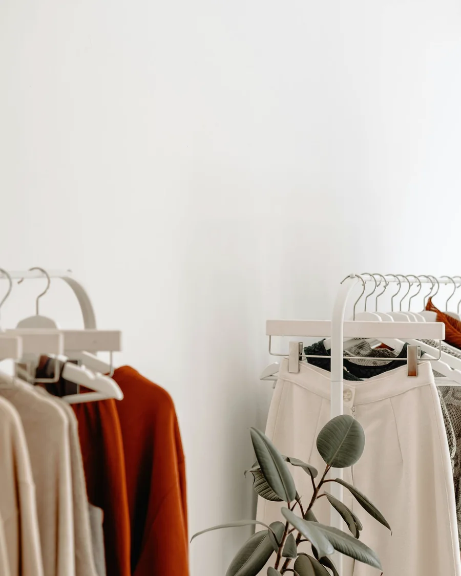 Cream wide-leg trousers hanging in a bright studio