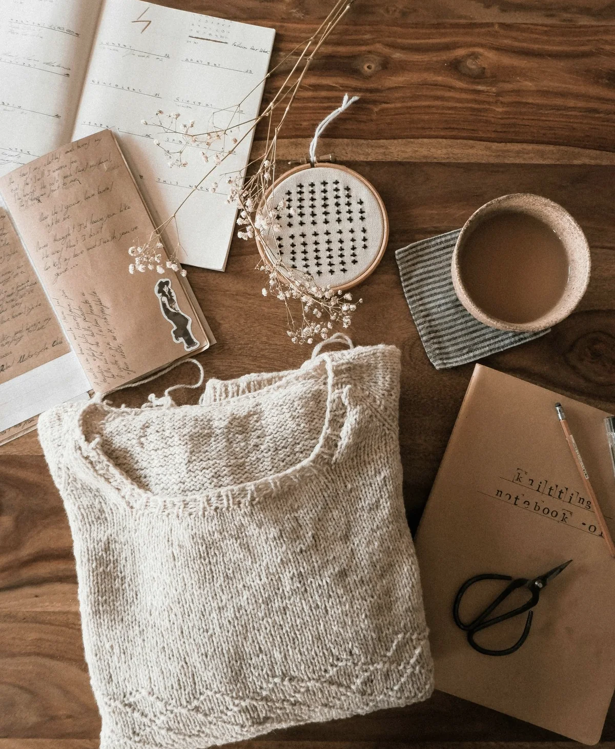 Fabric sample, sketchbook and tools on a maker's worktable