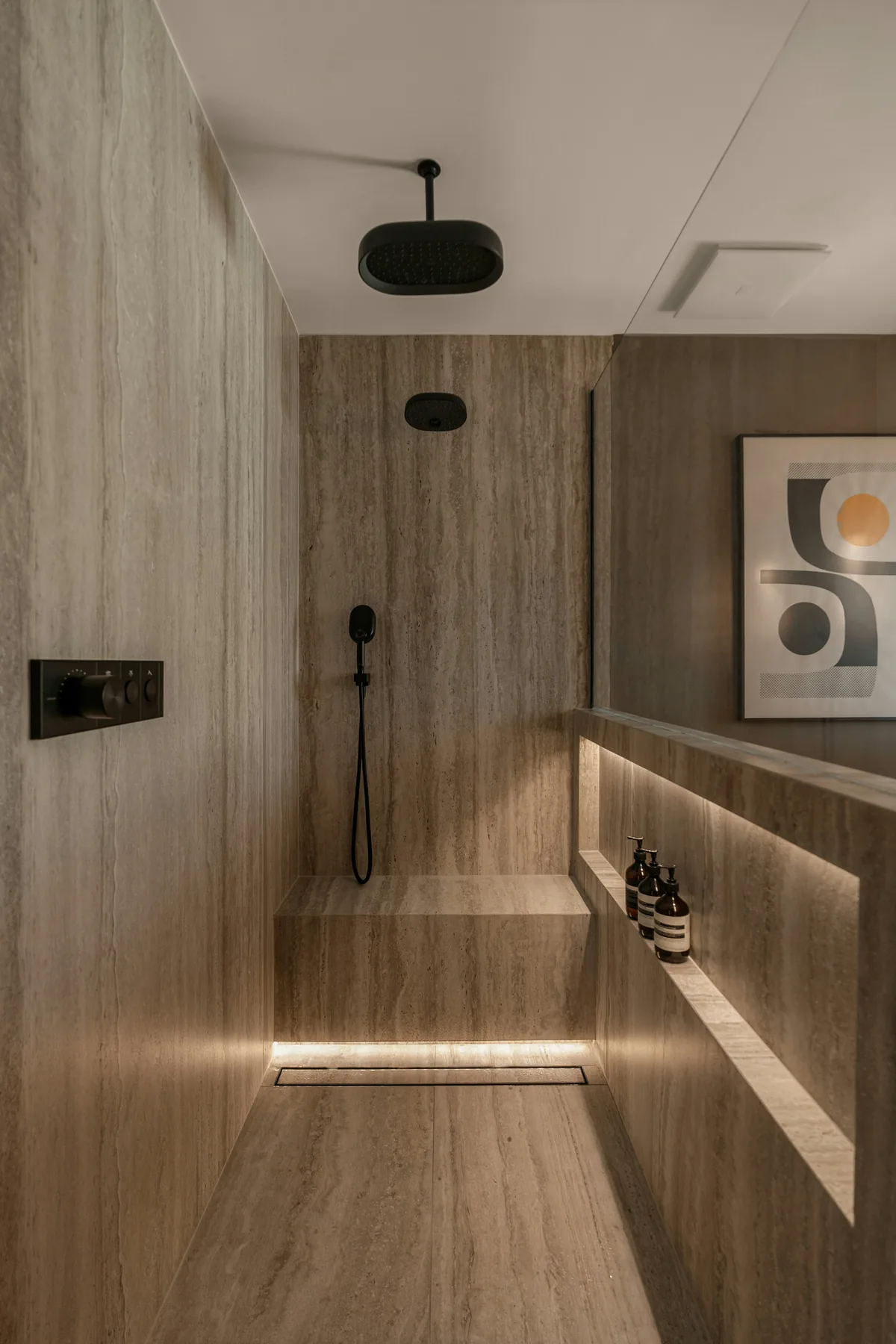 Minimal travertine shower with ambient lighting