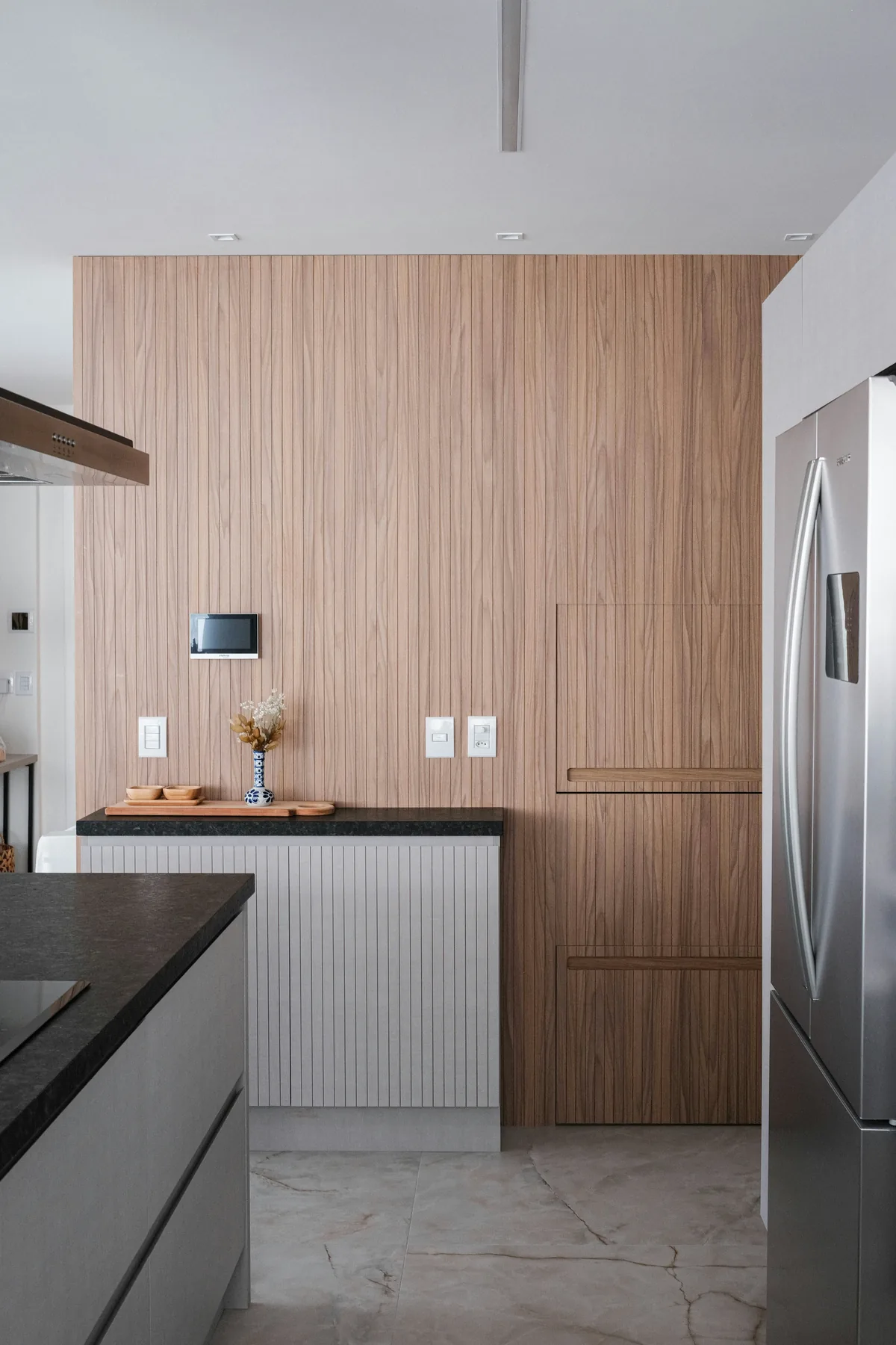 Minimal kitchen with finely detailed timber wall